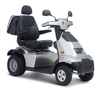 A silver mobility scooter with a black seat and armrests. It has four wheels, a closed storage compartment at the back, a handlebar controlling the scooter, and mirrors on both sides.